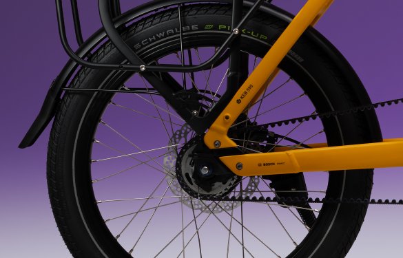 Hinterrad von kompaktem E-Bike auf lila Hintergrund
