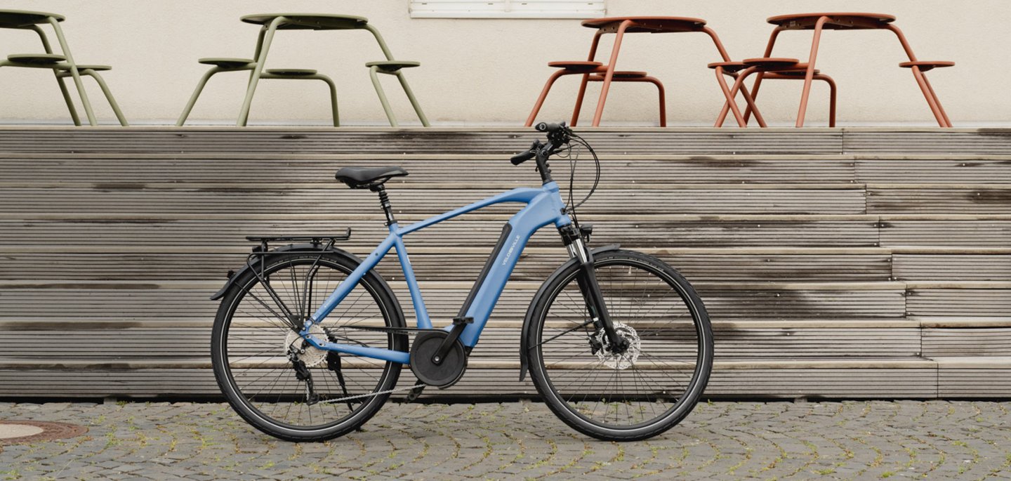 Blaues E-Bike vor Treppe