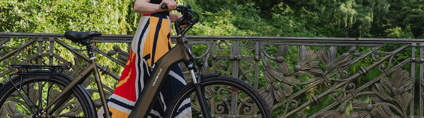 Frau mit E-Bike auf Brücke