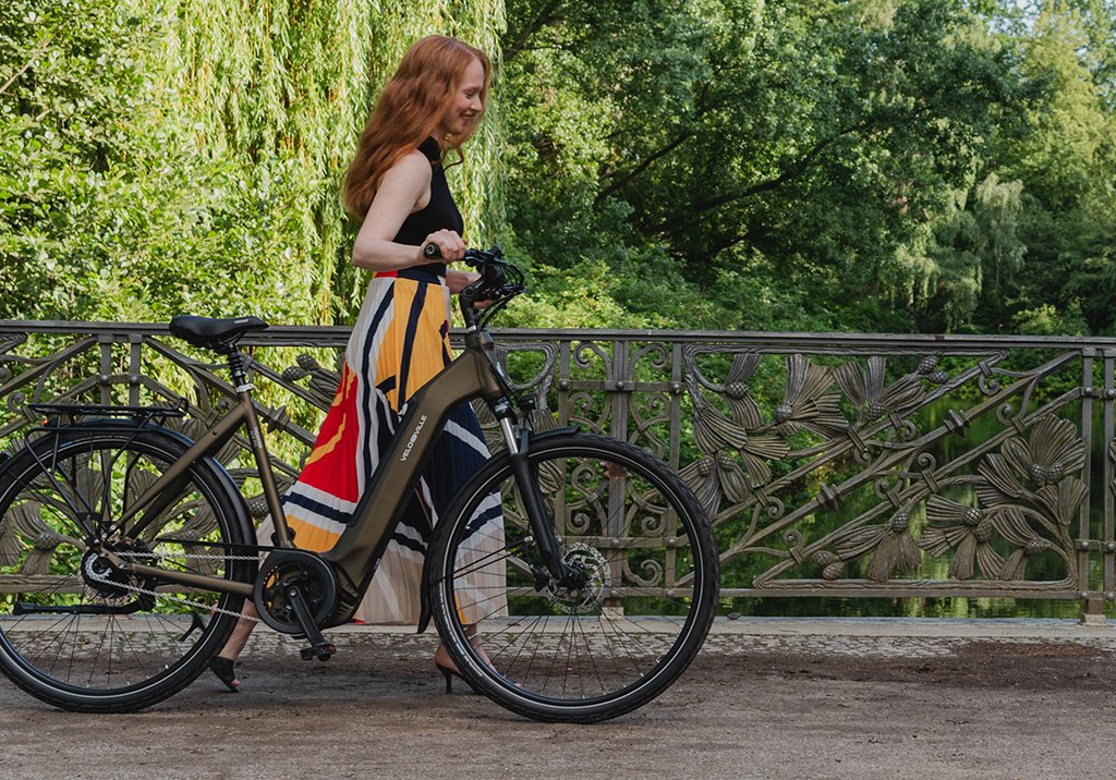 Frau mit E-Bike auf Brücke