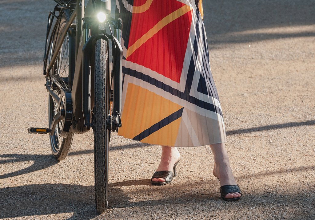 Frau mit Rock neben eingeschalteter E-Bike Beleuchtung