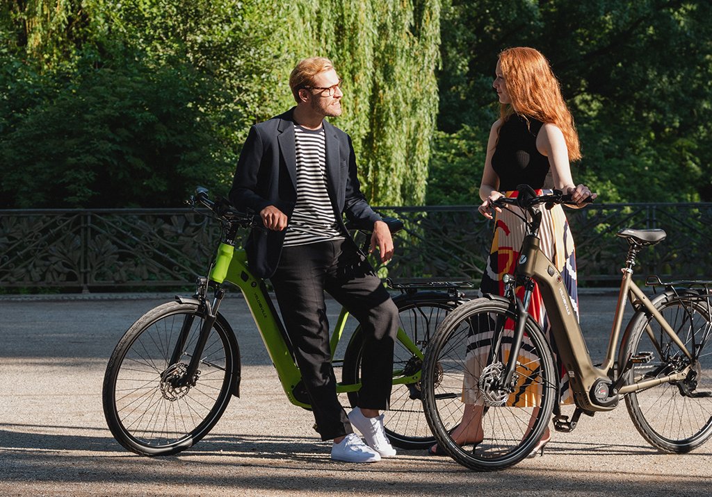 Mann und Frau mit E-Bikes unterhalten sich